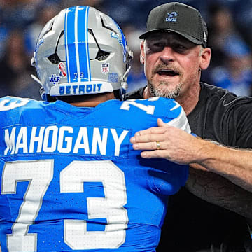 Detroit Lions head coach Dan Campbell hugs guard Christian Mahogany (73) during warm up at Ford Field in Detroit on Sunday, Sept. 14, 2025.