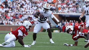 Sep 13, 2025; Auburn, Alabama, USA;  Auburn Tigers running back Omar Mabson II (29) carries between South Alabama Jaguars defenders during the third quarter at Jordan-Hare Stadium. Mandatory Credit: John Reed-Imagn Images
