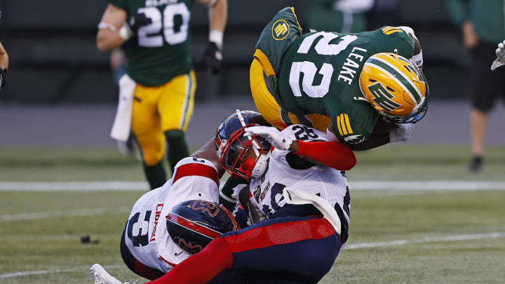 Jun 14, 2024; Edmonton, Alberta, CAN; Edmonton Elks running back Javon Leake (22) is tackled by Montreal Alouettes wide receiver Regis Cibasu (3) and Montreal Alouettes linebacker Tyrice Beverette (26) during the second half at Commonwealth Stadium. Mandatory Credit: Perry Nelson-USA TODAY Sports