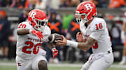 Nov 1, 2025; Champaign, Illinois, USA;  Rutgers Scarlet Knights quarterback Athan Kaliakmanis (16) hands the ball to  running back Ja'shon Benjamin (20) during the second half against the Illinois Fighting Illini  at Memorial Stadium.  Credit: Ron Johnson-Imagn Images