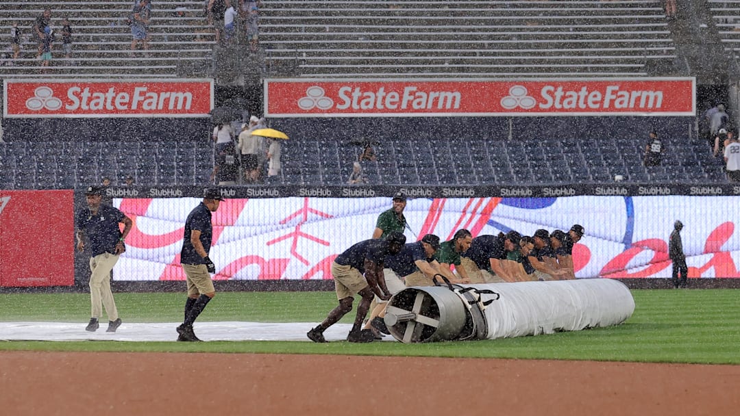 Jul 31, 2025; Bronx, New York, USA; Yankee Stadium grounds crew rolls the tarp onto the infield during a rain delay during the fifth inning between the New York Yankees and the Tampa Bay Rays at Yankee Stadium. Mandatory Credit: Brad Penner-Imagn Images Jul 31, 2025; Bronx, New York, USA; Yankee Stadium grounds crew rolls the tarp onto the infield during a rain delay during the fifth inning between the New York Yankees and the Tampa Bay Rays at Yankee Stadium. Mandatory Credit: Brad Penner-Imagn Images