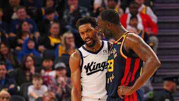 Jan 5, 2025; San Francisco, California, USA; Sacramento Kings guard Malik Monk (0) and Golden State Warriors forward Draymond Green (23) between plays during the third quarter at Chase Center. Mandatory Credit: Kelley L Cox-Imagn Images
