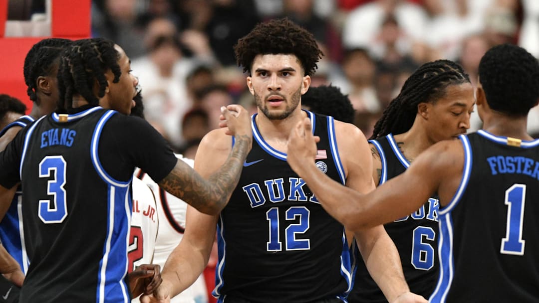 Mar 2, 2026; Raleigh, North Carolina, USA;  Duke basketball forward Cameron Boozer (12) reacts with guard Isaiah Evans (3) and guard Caleb Foster (1) after being fouled during the first half against the NC State Wolfpack at Lenovo Center.