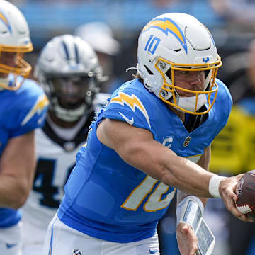 Sep 15, 2024; Charlotte, North Carolina, USA; Los Angeles Chargers quarterback Justin Herbert (10) hands off during the second half against the Carolina Panthers at Bank of America Stadium. Mandatory Credit: Jim Dedmon-Imagn Images