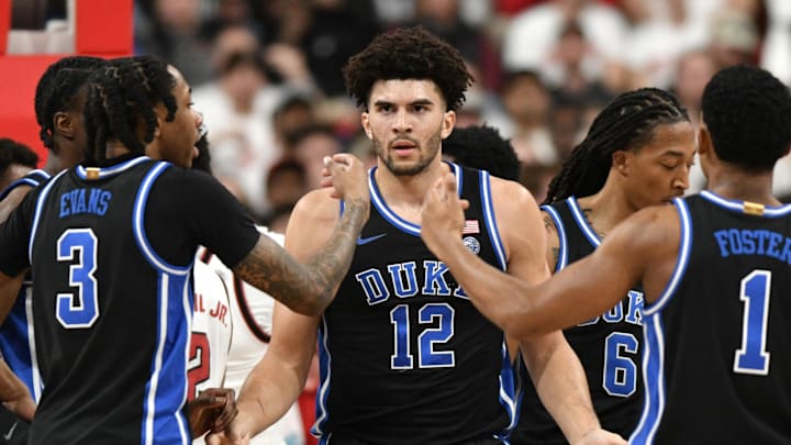 Mar 2, 2026; Raleigh, North Carolina, USA;  Duke basketball forward Cameron Boozer (12) reacts with guard Isaiah Evans (3) and guard Caleb Foster (1) after being fouled during the first half against the NC State Wolfpack at Lenovo Center.