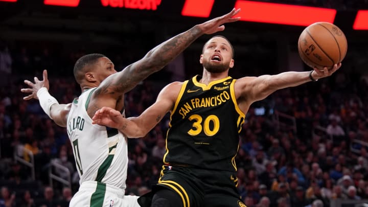 Golden State Warriors guard Stephen Curry (30) shoots the ball while being defended by Milwaukee Bucks guard Damian Lillard (0) in the third quarter at the Chase Center. Mandatory Credit: