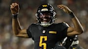 Oct 13, 2025; Landover, Maryland, USA; Washington Commanders quarterback Jayden Daniels (5) celebrates after throwing a touchdown pass against the Chicago Bears during the fourth quarter at Northwest Stadium. Mandatory Credit: Geoff Burke-Imagn Images