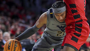 Mar 9, 2024; Cincinnati, Ohio, USA; West Virginia Mountaineers guard RaeQuan Battle (21) dribbles against the Cincinnati Bearcats in the second half at Fifth Third Arena. Mandatory Credit: Katie Stratman-Imagn Images