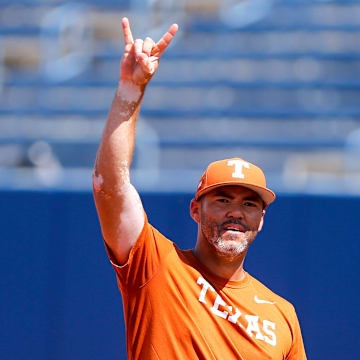 Associate head coach Steve Singleton pitches while the Texas softball team takes the field during the practice and media day for the Women's College World Series at Devon Park in Oklahoma City, on Wednesday, May 29, 2024.