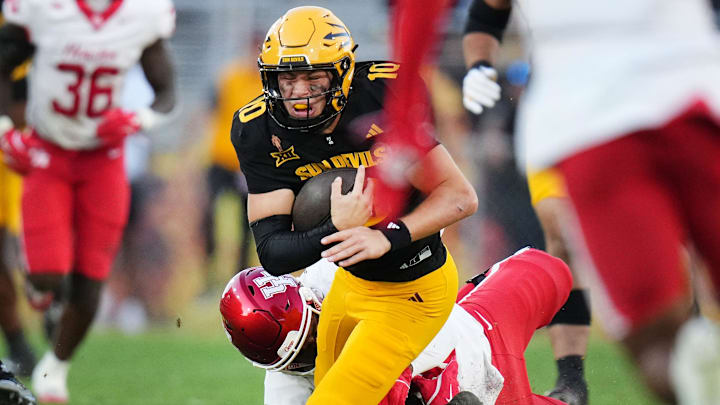 ASU Sun Devils quarterback Sam Leavitt (10) is hurt while being dragged down by Houston Cougars defensive lineman Eddie Walls III (90) at Mountain America Stadium in Tempe on Oct. 25, 2025.