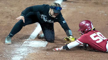 Oklahoma's Ailana Agbayani (50) is tagged out by UCF's Aubrey Evans (3) during the college softball game between the University of Oklahoma Sooners and the UCF Knights at Love's Field in Norman, Okla., Friday, April, 4, 2025.