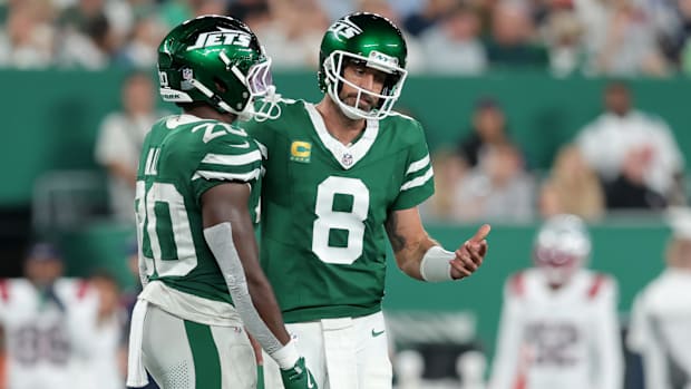 Jets quarterback Aaron Rodgers (8) reacts as he talks to running back Breece Hall (20) during a game against the Patriots.