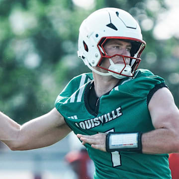 Louisville Cardinals quarterback Miller Moss during a morning practice Wednesday, July 30, 2025. Moss transferred from USC. His overall QB rating is 81.4. At left is UofL quarterbacks coach and offensive coordinator Brian Brohm.