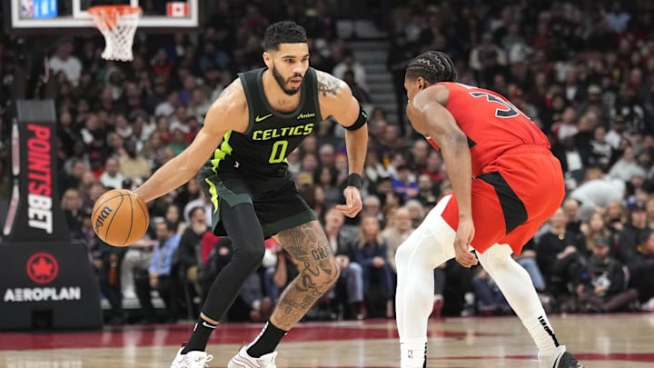 Jan 15, 2025; Toronto, Ontario, CAN; Boston Celtics forward Jayson Tatum (0) dribbles against Toronto Raptors guard Ochai Agbaji (30) during the first half at Scotiabank Arena. Mandatory Credit: John E. Sokolowski-Imagn Images