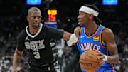 Mar 2, 2025; San Antonio, Texas, USA;  Oklahoma City Thunder guard Shai Gilgeous-Alexander (2) dribbles past San Antonio Spurs guard Chris Paul (3) in the second half at Frost Bank Center. Mandatory Credit: Daniel Dunn-Imagn Images