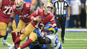 Sep 22, 2024; Inglewood, California, USA;  San Francisco 49ers quarterback Brock Purdy (13) is stopped by Los Angeles Rams defensive tackle Braden Fiske (55) and defensive tackle Kobie Turner (91) for a first down in the second half at SoFi Stadium. Mandatory Credit: Jayne Kamin-Oncea-Imagn Images
