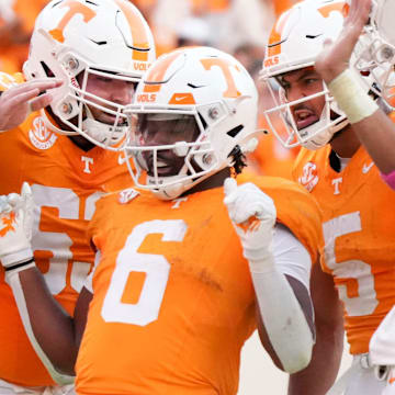 Tennessee offensive lineman Cooper Mays (63), wide receiver Bru McCoy (5), and quarterback Nico Iamaleava (8) surround running back Dylan Sampson (6) in celebration after Sampson's touchdown during an NCAA college football game against Alabama on Saturday, Oct. 19, 2024, in Knoxville. Tenn.