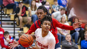 Fishers High School freshman Jason Gardner (5) drives the ball along the baseline while being defended by Kokomo High School sophomore Baris Moore (15) during the first half of a game in the Forum Tipoff Classic, Saturday, Dec. 9, 2023, at Southport High School.