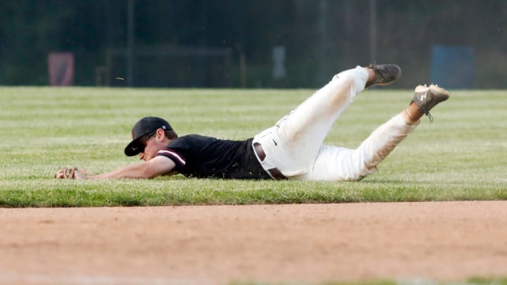 John Glenn senior Colt Emerson dives after a ball in the hole at shortstop during the sixth inning of a 5-0 loss to Tri-Valley on May 22, 2023, during a Division II district semifinal at Lake Park in Coshocton. 