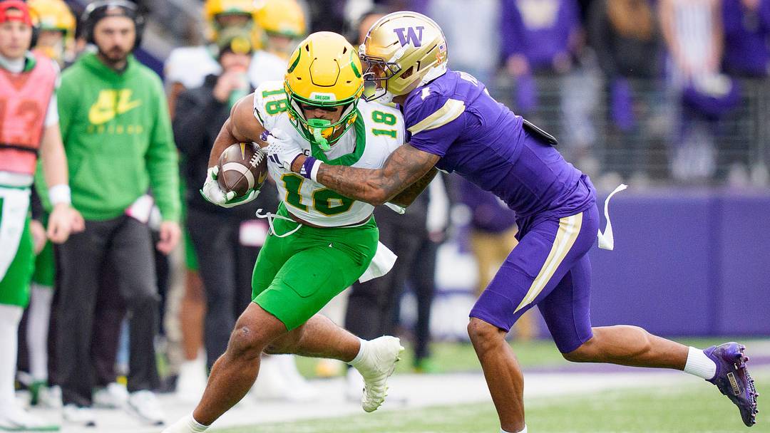 Oregon tight end Kenyon Sadiq carries the ball under cover from Washington cornerback Ephesians Prysock as the Oregon Ducks take on the Washington Huskies on Nov. 29, 2025, at Husky Stadium in Seattle, Washington.
