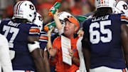 Oct 18, 2025; Auburn, Alabama, USA;  Auburn Tigers head coach Hugh Freeze talks with offensive lineman Jeremiah Wright (77) during the first quarter against the Missouri Tigers at Jordan-Hare Stadium. Mandatory Credit: John Reed-Imagn Images