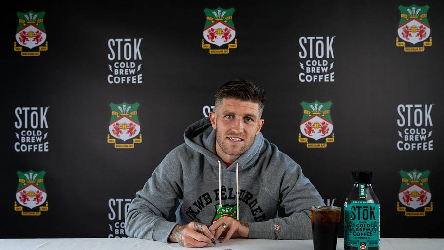 Josh Windass signs his Wrexham contract.