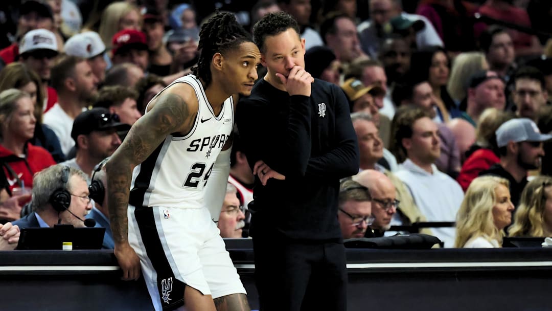 Apr 26, 2026; Portland, Oregon, USA; San Antonio Spurs coach Mitch Johnson talks with guard Devin Vassell (24) during the first half against the Portland Trail Blazers during Game 4 of the first round of the 2026 NBA Playoffs at Moda Center.