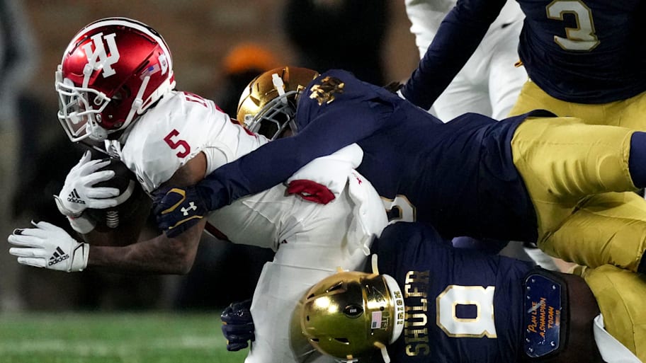 Indiana Hoosiers wide receiver Ke'Shawn Williams is tackled by Notre Dame Fighting Irish defenders during the CFP.