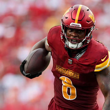 Sep 8, 2024; Tampa, Florida, USA; Washington Commanders running back Brian Robinson Jr. (8) breaks a tackle from Tampa Bay Buccaneers linebacker K.J. Britt (52) in the third quarter at Raymond James Stadium. Mandatory Credit: Nathan Ray Seebeck-Imagn Images