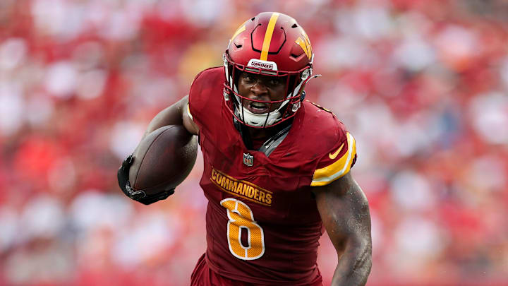 Sep 8, 2024; Tampa, Florida, USA; Washington Commanders running back Brian Robinson Jr. (8) breaks a tackle from Tampa Bay Buccaneers linebacker K.J. Britt (52) in the third quarter at Raymond James Stadium. Mandatory Credit: Nathan Ray Seebeck-Imagn Images