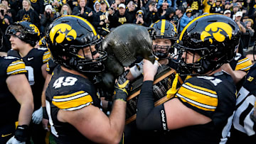 Iowa Hawkeyes defensive lineman Ethan Hurkett (49) helps carry the Floyd of Rosedale Trophy after the Hawkeyes defeated Minnesota Oct. 25, 2025 at Kinnick Stadium in Iowa City, Iowa.