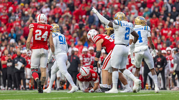 Nebraska quarterback Dylan Raiola is helped up by offensive lineman Bryce Benhart after being sacked for a 10-yard loss.