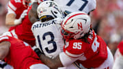 Nebraska defensive lineman Gabe Moore combines with Javin Wright to bring down Akron's Sean Patrick.