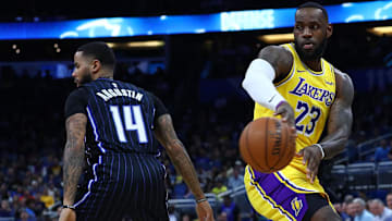  Los Angeles Lakers forward LeBron James (23) passes the ball around former Orlando Magic guard D.J. Augustin (14) during the first quarter at Amway Center.