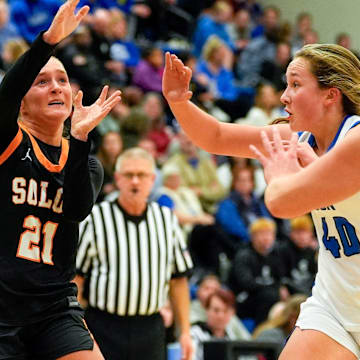 Solon’s Laeni Hinkle (21) passes the ball over Clear Creek Amana’s Lydia Keller (40) and Lena Evans (15) Dec. 5, 2025 during a girls basketball game in Tiffin, Iowa.