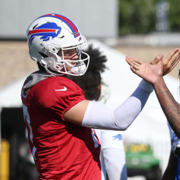 Bills quarterback Josh Allen goes through a unique handshake with every player in his offensive unit, including running back James Cook, during their pre practice ritual.