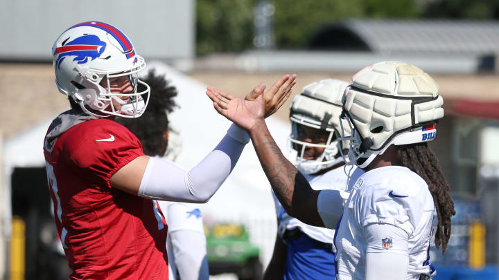 Bills quarterback Josh Allen goes through a unique handshake with every player in his offensive unit, including running back James Cook, during their pre practice ritual.