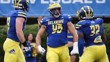 Delaware's Melkart Abou-Jaoude celebrates a third quarter sack with Trace Scott (left) and Marje Mulumba in the Blue Hens' 49-0 win at Delaware Stadium, Saturday, Sept. 28, 2024.