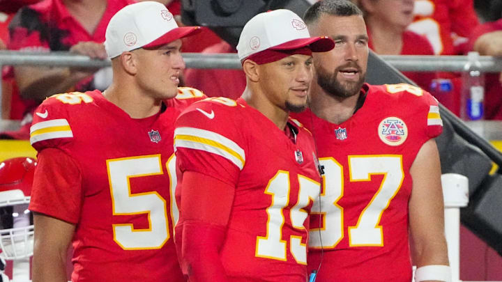 Kansas City Chiefs defensive end George Karlaftis (56) and quarterback Patrick Mahomes (15), and tight end Travis Kelce (87) watch play against the Chicago Bears during the second half of the game at GEHA Field at Arrowhead Stadium.