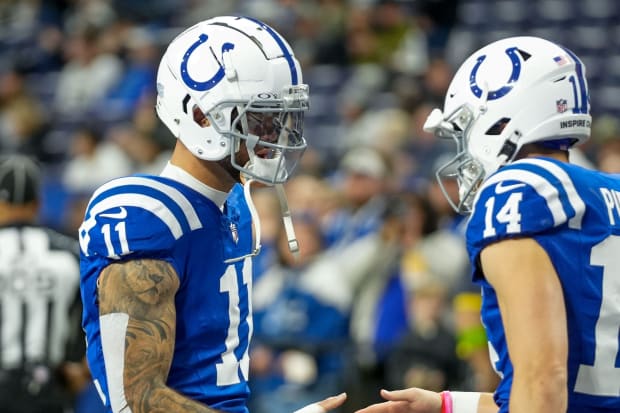 Indianapolis Colts wide receiver Michael Pittman Jr. shakes hands with teammate Alec Pierce in blue jerseys.