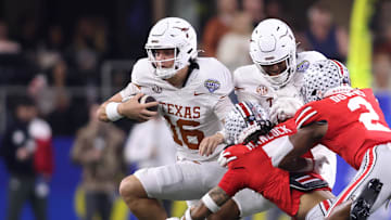 Jan 10, 2025; Arlington, Texas, USA; Texas Longhorns quarterback Arch Manning (16) runs against Ohio State Buckeyes cornerback Jordan Hancock (7) and safety Caleb Downs (2) during the second quarter of the College Football Playoff semifinal in the Cotton Bowl at AT&T Stadium. Mandatory Credit: Tim Heitman-Imagn Images