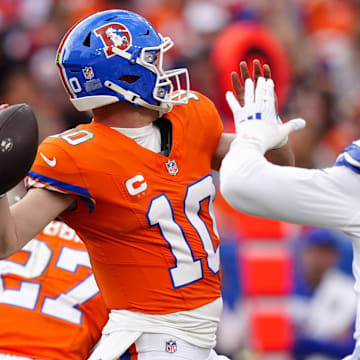 Denver Broncos quarterback Bo Nix throws a pass against Dallas Cowboys defensive end Donovan Ezeiruaku.