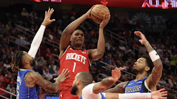 Nov 3, 2025; Houston, Texas, USA ;Houston Rockets guard Amen Thompson (1) passes against Dallas Mavericks forward Caleb Martin (16), guard D'Angelo Russell (5) and  forward P.J. Washington (25) in the second quarter at Toyota Center. Mandatory Credit: Thomas Shea-Imagn Images