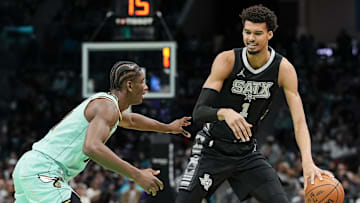 Feb 7, 2025; Charlotte, North Carolina, USA;  San Antonio Spurs center Victor Wembanyama (1) handles the ball against Charlotte Hornets forward Moussa Diabate (14) during the second half at Spectrum Center. Mandatory Credit: Jim Dedmon-Imagn Images