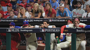 Oct 5, 2024; Philadelphia, PA, USA; Philadelphia Phillies players look out from the dugout in the ninth inning against the New York Mets in game one of the NLDS for the 2024 MLB Playoffs at Citizens Bank Park. Mandatory Credit: Eric Hartline-Imagn Images