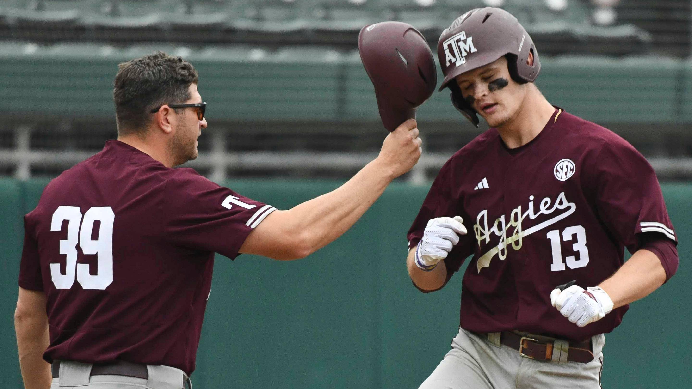 Texas A&M assistant coach Nolan Cain congratulates Caden Sorrell as he rounds third after hitting a grand slam against Alabama at Sewell-Thomas Stadium in the first game of a double header Friday.