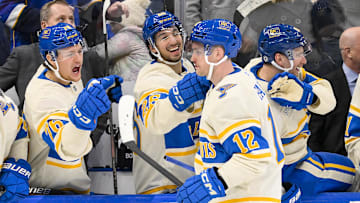 Feb 8, 2025; St. Louis, Missouri, USA;  St. Louis Blues center Radek Faksa (12) is congratulated by center Zack Bolduc (76) and center Jordan Kyrou (25) after scoring the game winning goal in the 10th round of shootouts against the Chicago Blackhawks at Enterprise Center. Mandatory Credit: Jeff Curry-Imagn Images