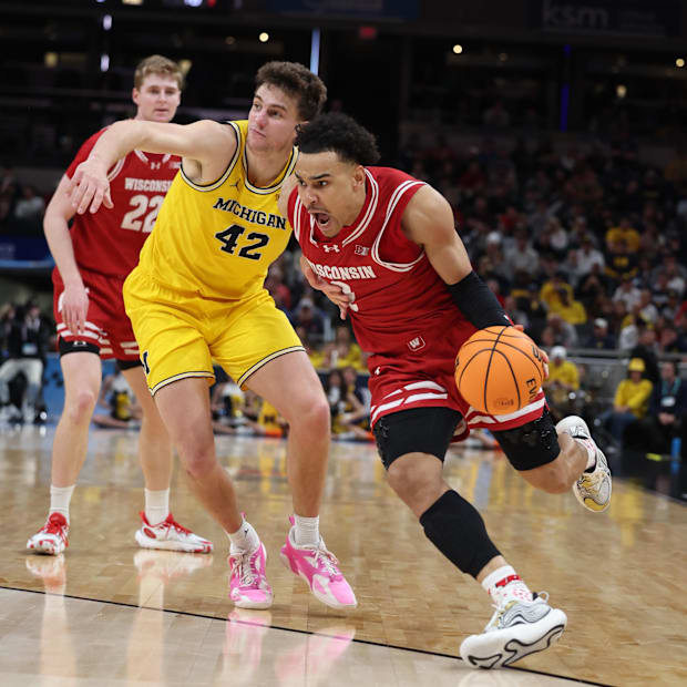 Wisconsin Badgers guard John Tonje (9) drives to the hoop past Michigan Wolverines forward Will Tschetter (42).