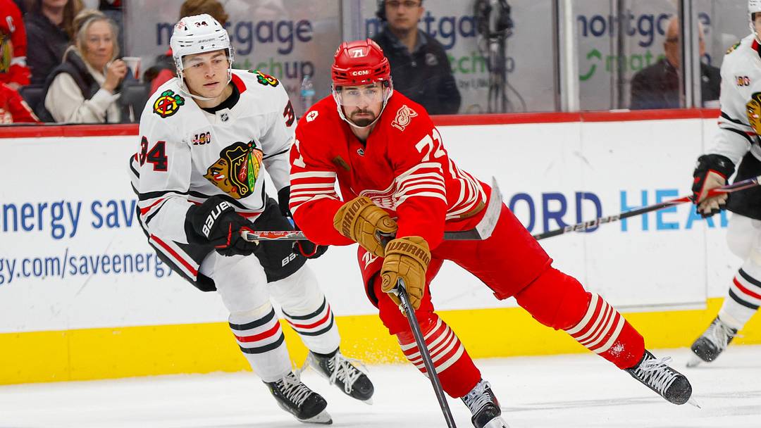 Nov 9, 2025; Detroit, Michigan, USA; Detroit Red Wings center Dylan Larkin (71) handles the puck against Chicago Blackhawks center Colton Dach (34) during the second period at Little Caesars Arena. Mandatory Credit: Brian Bradshaw Sevald-Imagn Images