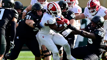 Nov 2, 2024; East Lansing, Michigan, USA; Indiana Hoosiers running back Justice Ellison (6) gets tackled by Michigan State Spartans defensive linemen Alex VanSumeren (91), Maverick Hansen (97) and Quindarius Dunnigan (99) during the first quarter at Spartan Stadium. Mandatory Credit: Dale Young-Imagn Images